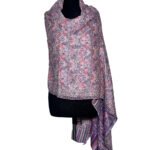 A light-colored Kani semi-pashmina shawl with pink and purple floral patterns draped on a mannequin.