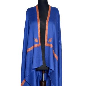 Luxurious sapphire blue semi-pashmina shawl with intricate burnt orange or rust-colored embroidery along the edges and in leaf motifs, elegantly draped on a black mannequin.